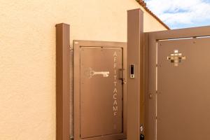 een deur met een bord aan de zijkant van een gebouw bij Affittacamere Lumal in Domus de Maria +11 foto's