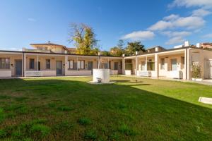 een groot gebouw met een groen gazon ervoor bij Affittacamere Lumal in Domus de Maria