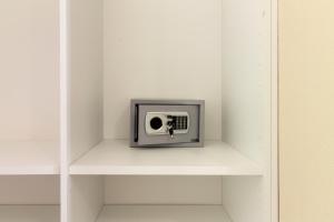 een kleine tv op een plank in een witte kamer bij Affittacamere Lumal in Domus de Maria