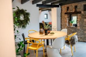 een eetkamer met een houten tafel en gele stoelen bij HofZeit 1 in Mechernich