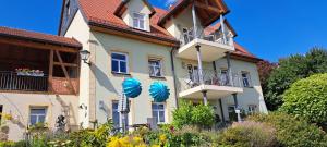a building with two balconies and flowers in front of it at Landhaus Andreus 