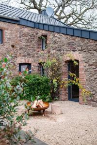 een bakstenen gebouw met een bank ervoor bij HofZeit 1 in Mechernich