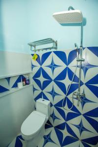 ein Bad mit einem WC und blauen und weißen Fliesen in der Unterkunft Most Kraton Malioboro Villa in Yogyakarta + 57 Fotos
