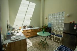 eine Küche mit einem kleinen Tisch und einem Kühlschrank in der Unterkunft Most Kraton Malioboro Villa in Yogyakarta