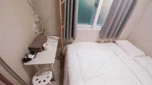 a small room with a bed and a window at 1971 Sinpung Inn in Seoul