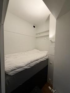 ein kleines weißes Zimmer mit einem Bett darin in der Unterkunft Moderne og møblert 2-roms leilighet i hjertet av Oslo in Oslo