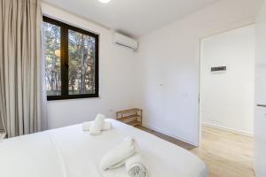 a white bedroom with a large window and a bed at Pine & Sea Retreat in Golem