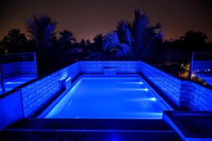 een zwembad 's nachts met blauwe lichten bij Hotel Beachfront - Couple & Family Friendly in Calangute +21 foto's
