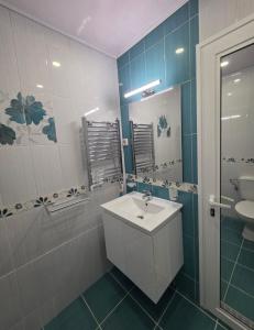 een badkamer met een wastafel en een spiegel bij APart Residence Shumen in Shumen