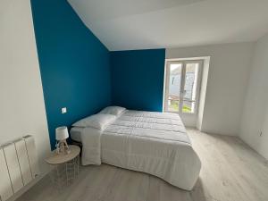 een slaapkamer met een bed en een blauwe muur bij Maison avec courette in Courlay