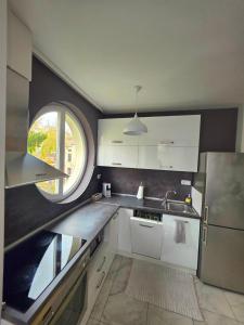 a kitchen with white cabinets and a large window at APart Residence Shumen in Shumen