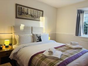 a bedroom with a bed with towels on it at Little Silver Country Hotel in Tenterden