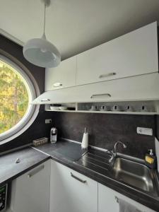 a kitchen with white cabinets and a sink and a window at APart Residence Shumen in Shumen +16 photos