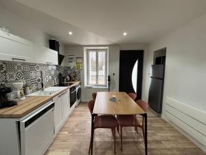 een keuken met een tafel en stoelen erin bij Maison avec courette in Courlay