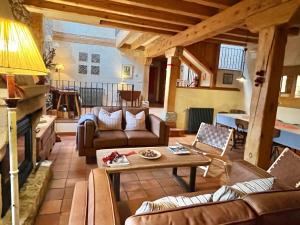 un soggiorno con divani e un tavolo di Saltus Abus, espectacular conjunto rural en Sotosalbos, 10min de Segovia a Sotosalbos