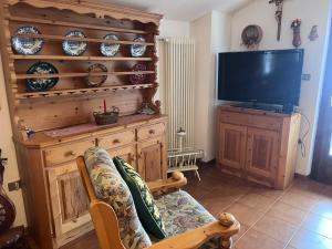 ein Wohnzimmer mit Sofa und Fernseher in der Unterkunft Il Rifugio del Brunone in Valda
