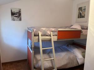 ein Zimmer mit zwei Etagenbetten und einer Leiter in der Unterkunft Il Rifugio del Brunone in Valda