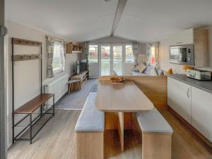 een keuken en een woonkamer met een houten tafel bij Edith Rose in Middleton