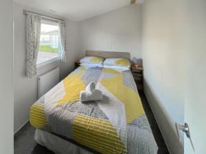 een slaapkamer met een bed met een geel-witte deken bij Edith Rose in Middleton