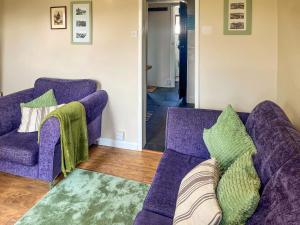 un soggiorno con 2 divani viola e un tappeto di Turning Tides Cottage a Scratby