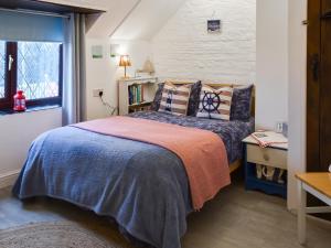 a bedroom with a bed and a window at Turning Tides Cottage in Scratby +13 photos