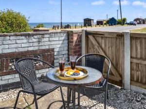 un tavolo con due sedie e due bicchieri di vino di Turning Tides Cottage a Scratby