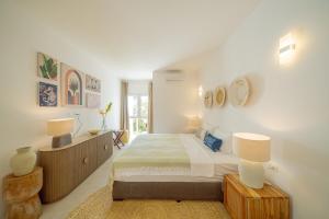 een witte slaapkamer met een bed en 2 lampen bij Two Bedroom Beach Front Apartment with pool in Kiwengwa