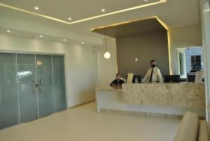 due persone sedute alla reception in una hall di Pousada Lagoa Seca a Juazeiro do Norte