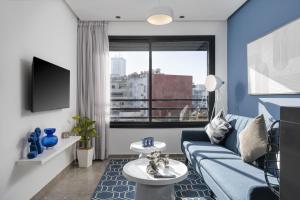 a living room with a blue couch and a window at Bright Modern Studio, Gauthier in Casablanca