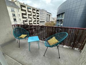 two chairs and a table on a balcony at Le TNB Rennes in Rennes