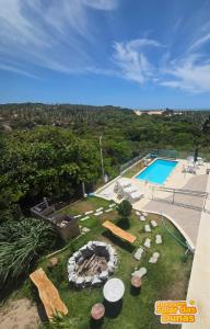 a backyard with a fire pit and a swimming pool at Estalagem Solar das Dunas in Pirambu