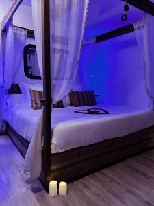 una camera da letto con due letti con tende e candele di La Villa Romane a Montfaucon Altre 59 foto