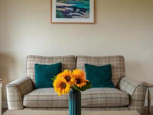 een vaas gevuld met gele bloemen in een woonkamer bij Dovecote - Uk47887 in Keilour