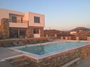 una villa con piscina di fronte a una casa di Villa Lina Syros ad Azólimnos