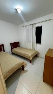 a room with two beds and a ceiling fan at Apartamento VOG praia do Sul ilhéus in Ilhéus +11 photos