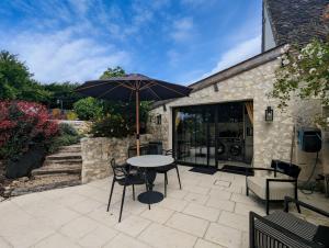 een tafel en stoelen met een parasol op een terras bij La Datcha in Paulnay