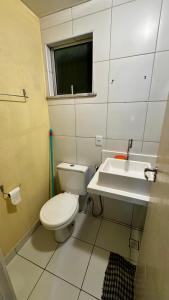 a bathroom with a toilet and a sink at Apartamento VOG praia do Sul ilhéus in Ilhéus