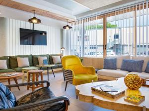 ein Wohnzimmer mit Couch, Stühlen und Tischen in der Unterkunft greet hotel Salon de Provence in Salon-de-Provence