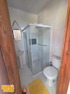 a bathroom with a glass shower and a toilet at Estalagem Solar das Dunas in Pirambu +33 photos