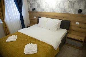 une chambre avec un lit avec deux serviettes blanches dessus dans l'établissement Apartmens in Kopaonik, à Kopaonik