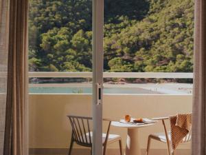 a room with a table and chairs and a large window at Hyde Hotel Ibiza Beach Resort by ACCOR in Cala Llonga +265 photos