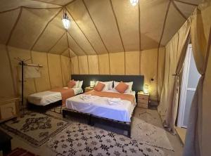 ein Schlafzimmer mit zwei Betten in einem Zelt in der Unterkunft Marruecos Desierto Camp Erg in Merzouga