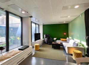 een woonkamer met een bank en een groene muur bij Lahtihovi in Lahti