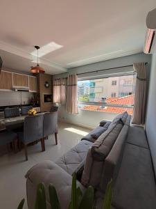 a living room with a couch and a table and a kitchen at Ap Praia De Palmas in Governador Celso Ramos