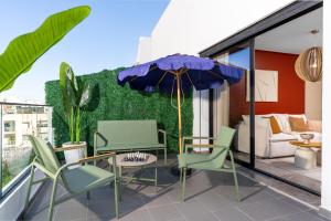 a patio with a table and chairs and an umbrella at Bright Modern Studio, Gauthier in Casablanca