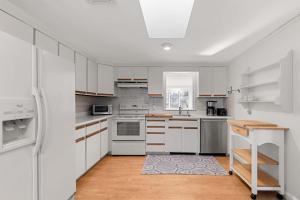 eine Küche mit weißen Schränken und weißen Geräten in der Unterkunft Steps to Bayside Beach Central AC Large Backyard in Brewster