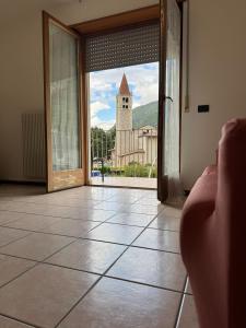 een persoon die door een deur naar een kerk kijkt bij La finestra su Mori in Mori +2 foto's