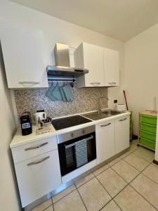 een kleine keuken met witte kasten en een spoelbak bij La finestra su Mori in Mori