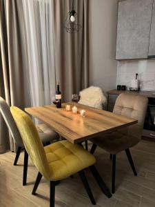 - une table à manger avec des chaises et des verres à vin dans l'établissement Apartmens in Kopaonik, à Kopaonik