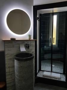 bagno con doccia e specchio rotondo di Suite Baccara a Cluis